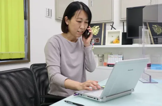 電話をしながらノートパソコンで作業する株式会社カラーズ代表取締役の田尻様